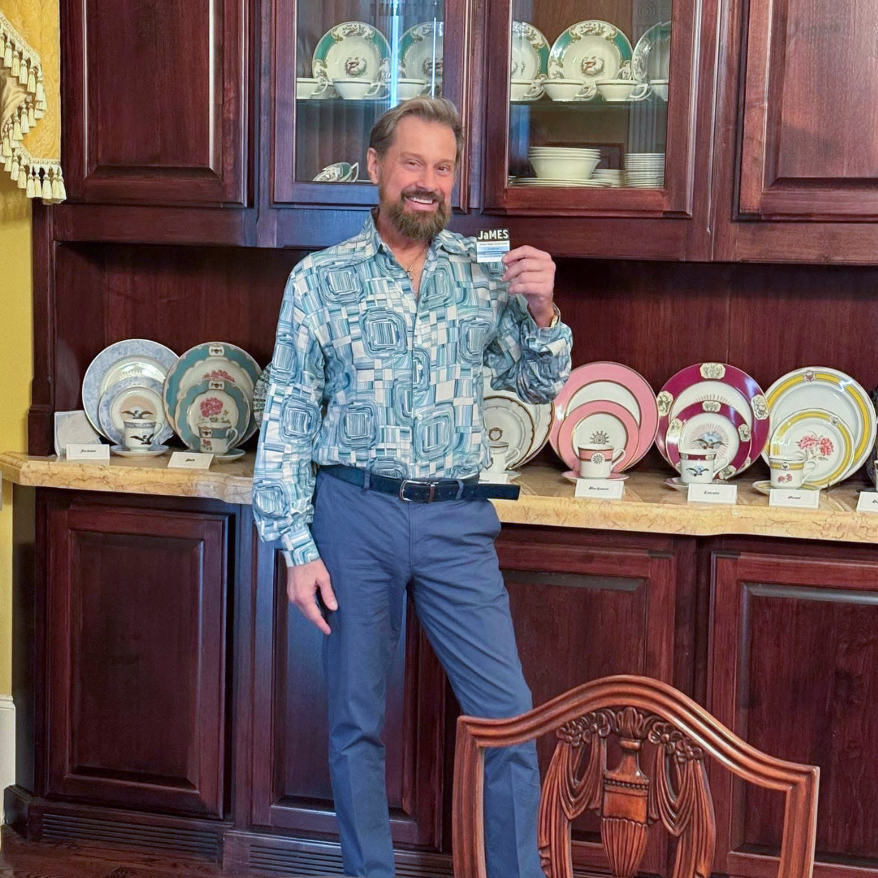 James Major standing in front of a curated display of antique china and collectible plates